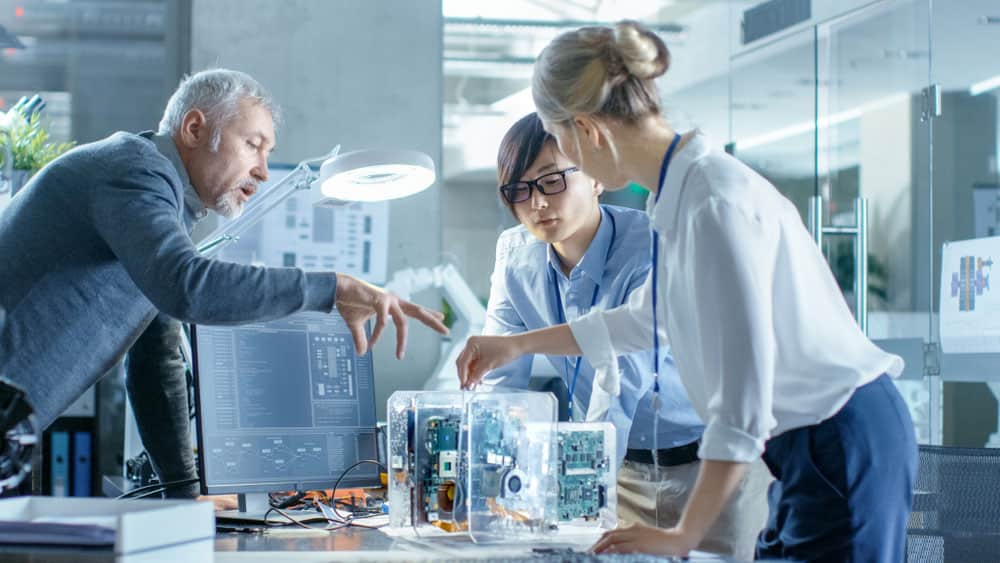 A team of computer engineers discussing a PCB to work with