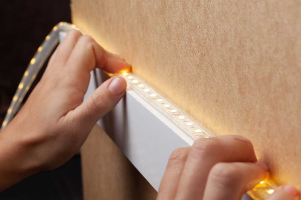 Master glues LED strip into a niche