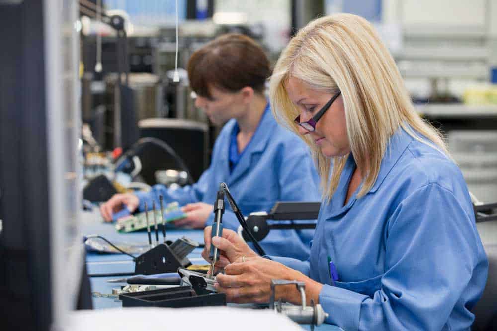 Female technicians soldering components onto a PCB